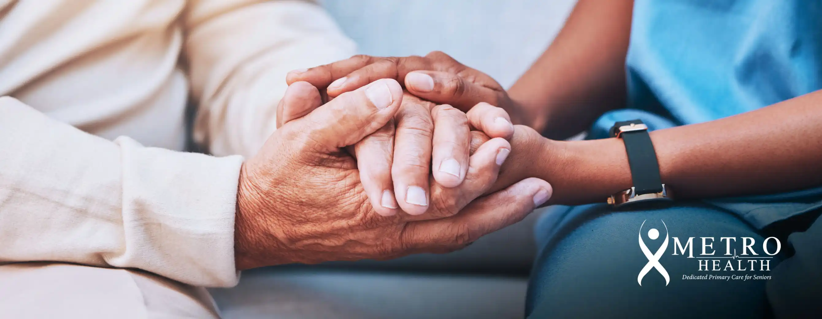 An elderly person’s hands held by a healthcare professional